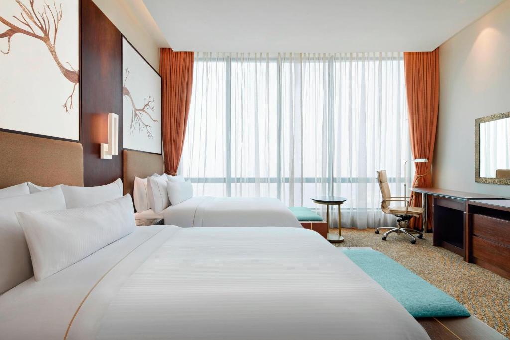 加尔各答加尔各答威斯汀酒店的酒店客房配有两张床和一张书桌