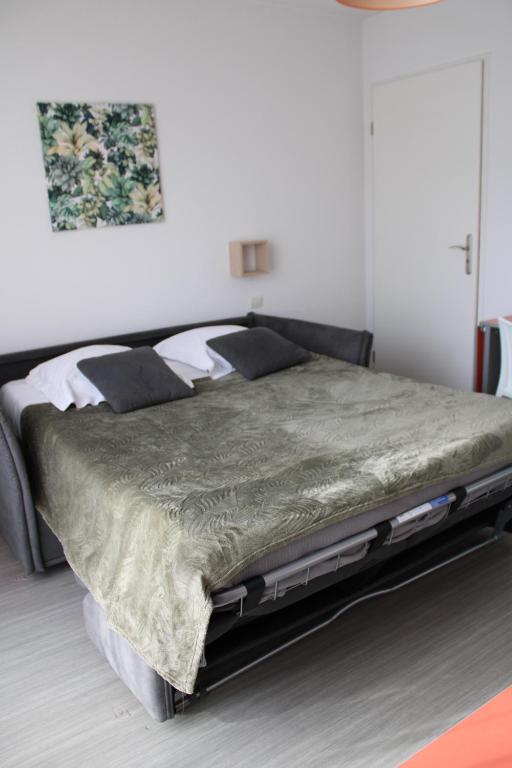 尼奥尔尼奥尔城市小屋公寓式酒店的一间卧室配有一张带绿色棉被的大床