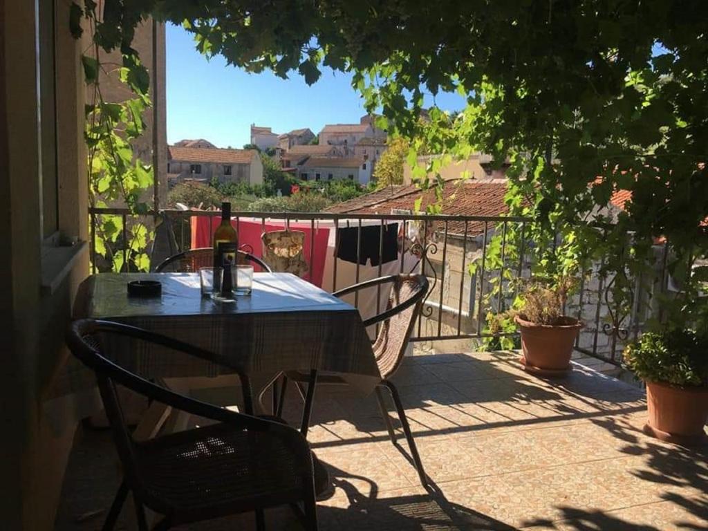 拉斯托伏Apartment Brezak的阳台上的桌子和一瓶葡萄酒