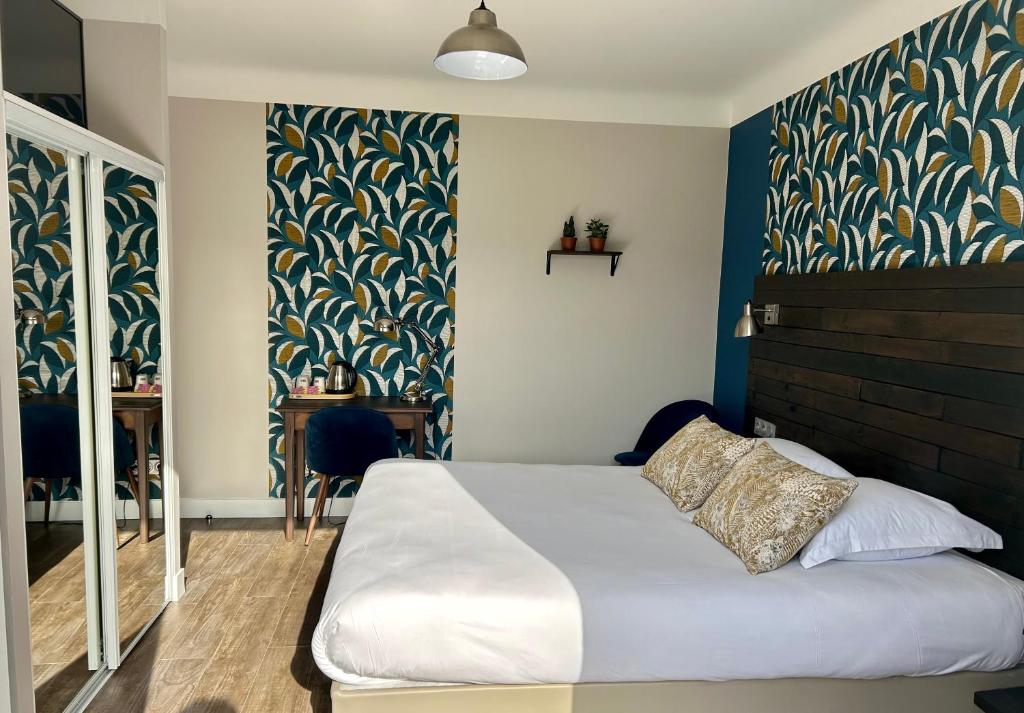 AldudesLOGIS Hôtel St Sylvestre的一间卧室设有一张床和蓝色的墙壁