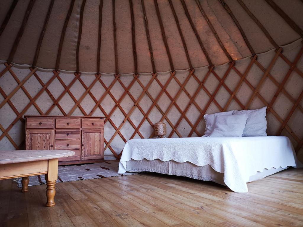 丰维耶Yourte au coeur du village的蒙古包内一间卧室,配有一张床和一张桌子