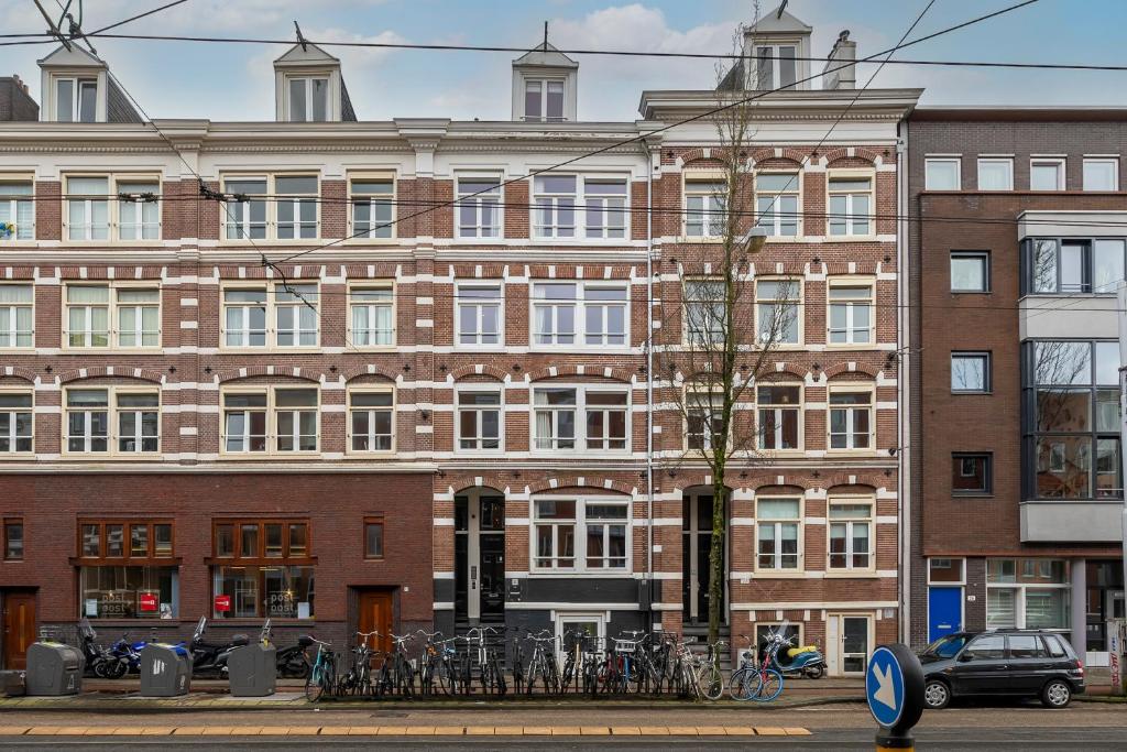 阿姆斯特丹Numa Amsterdam Oosterpark的一座大型砖砌建筑,前面停放着自行车