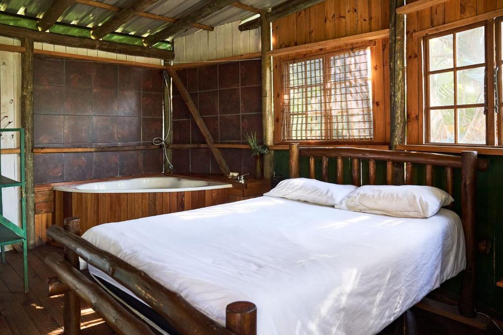 希伯丁Mantis and Moon Backpackers and Surf Hostel的一间卧室配有一张床和浴缸