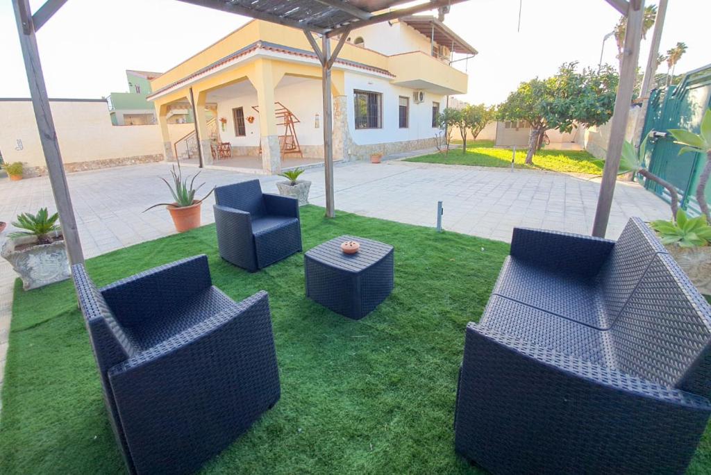 阿雷内拉Villa La Sosta - 150m dal mare - Patio Privato e Areal Relax的一个带椅子和桌子的院子和房子