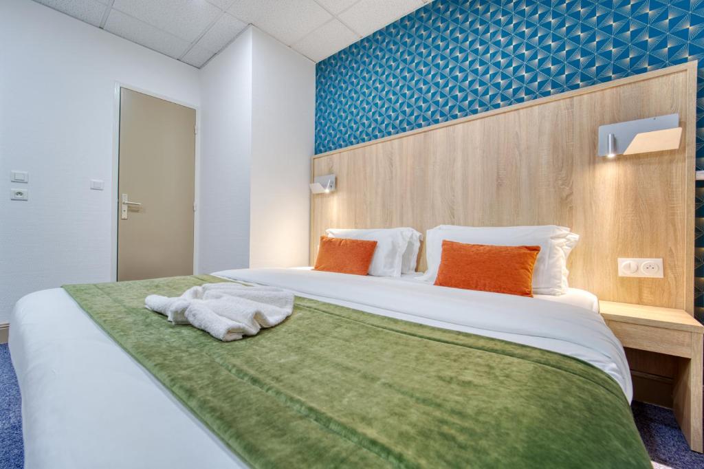 梅斯Hôtel Escurial - Centre Gare的一间卧室配有一张大床和毛巾
