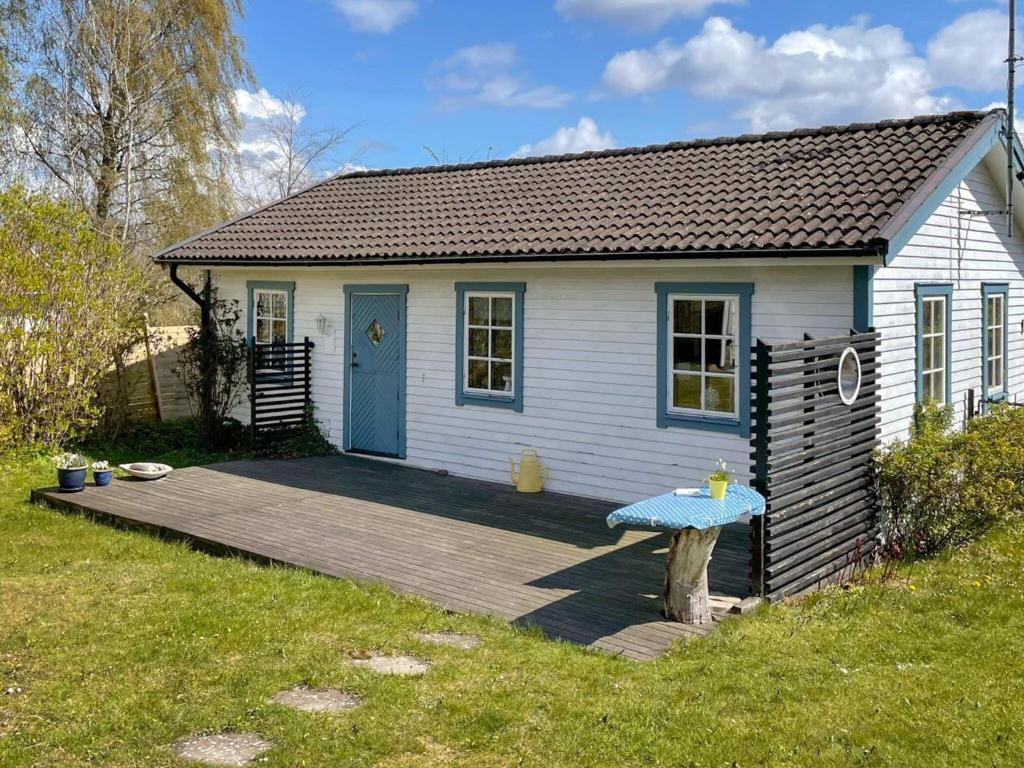 阿里尔德7 person holiday home in ARILD的一间白色的小房子,设有蓝色的门