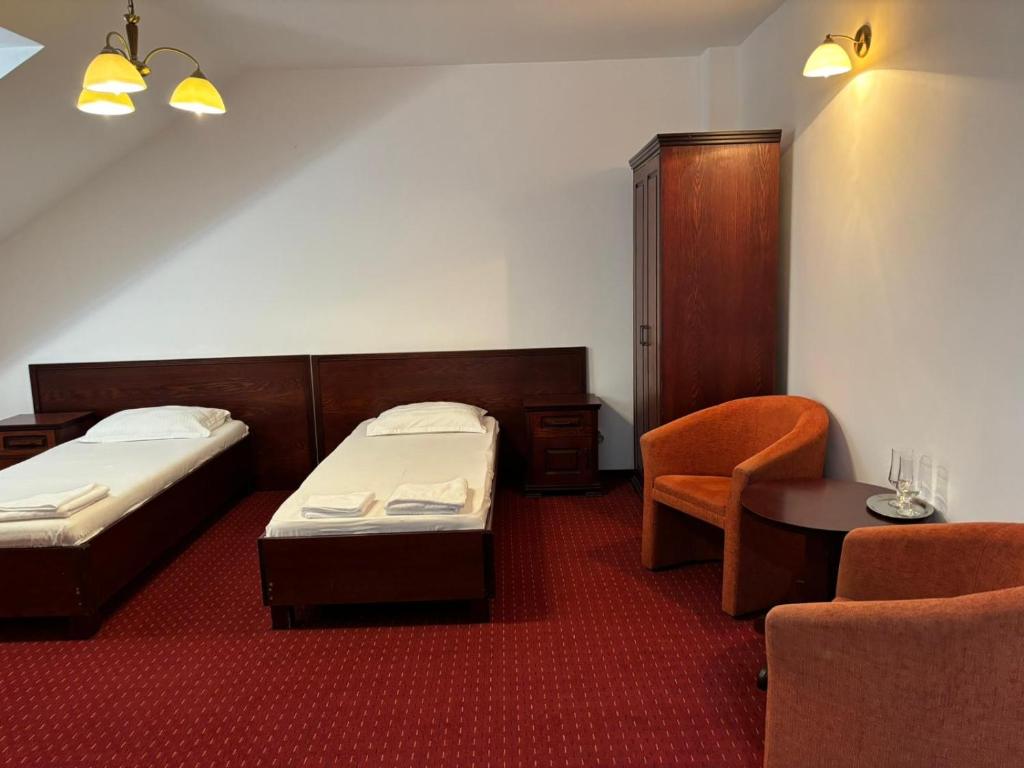 代日Hotel Elyon Dej的酒店客房,配有两张床和椅子