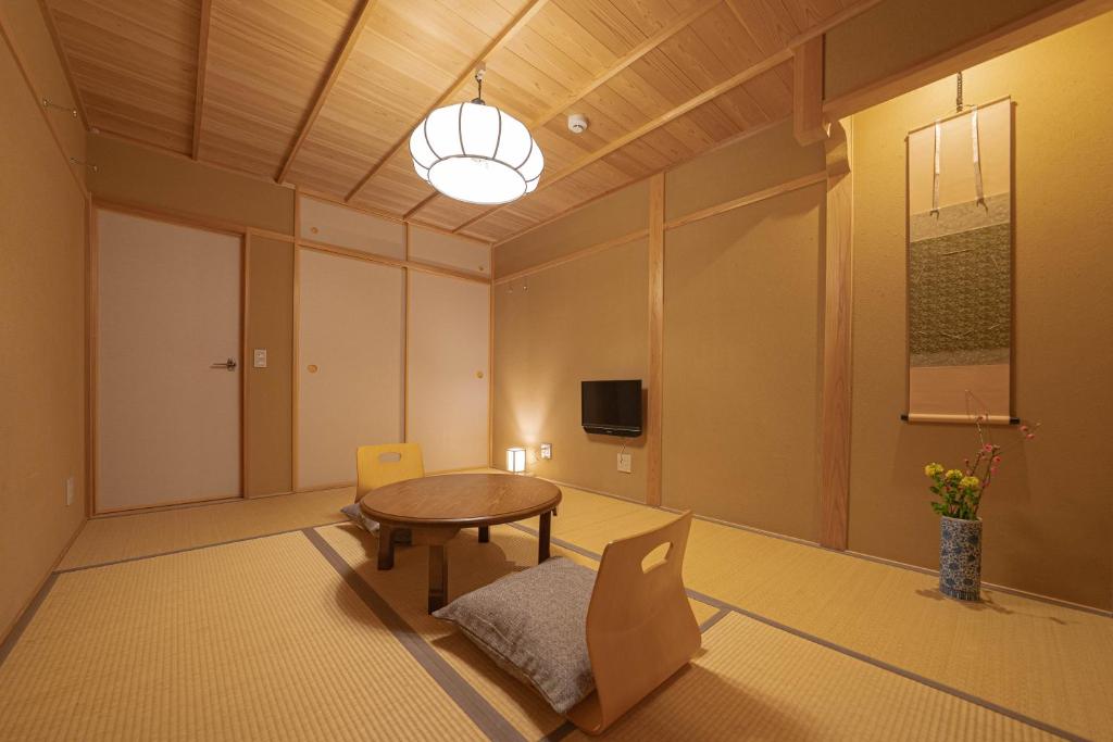 京都Saju Kyoto 茶住 京都的配有桌椅和电视的客房