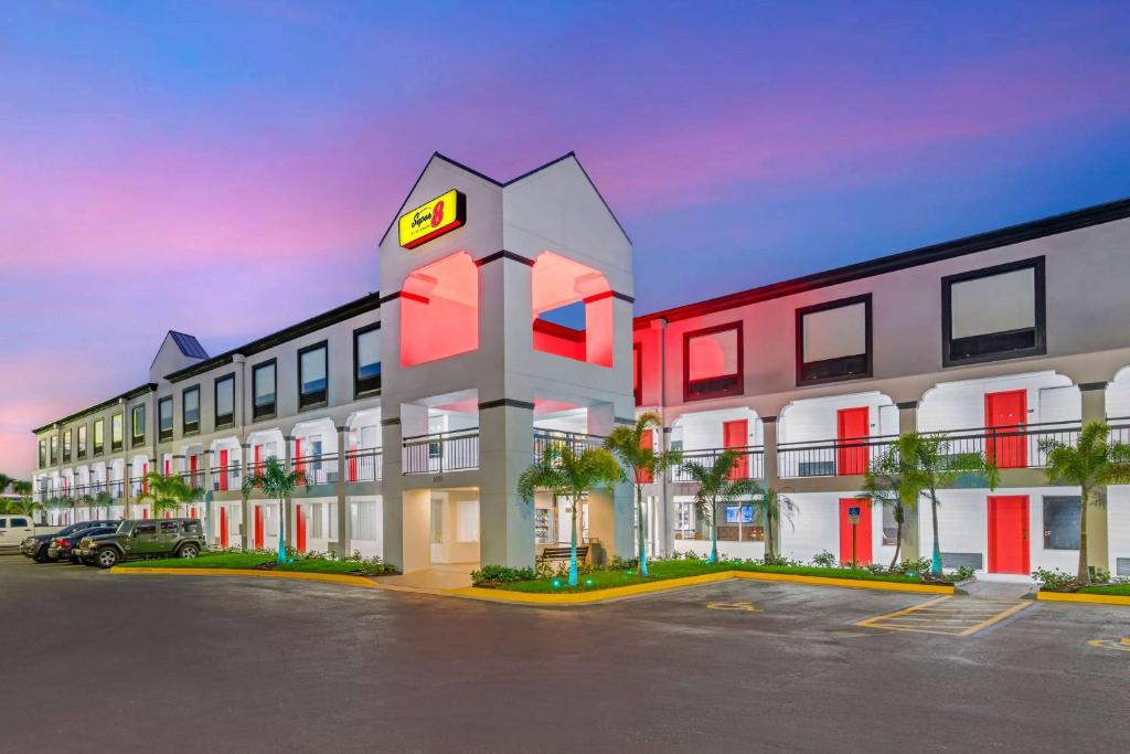 奥兰多Super 8 by Wyndham Orlando Near Florida Mall的在停车场有钟楼的酒店