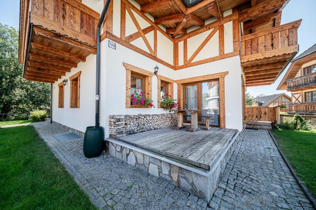 塔查斯卡-鲁穆尼卡Tatrachalet Lomnica Rent的一个带木屋顶门廊的度假屋