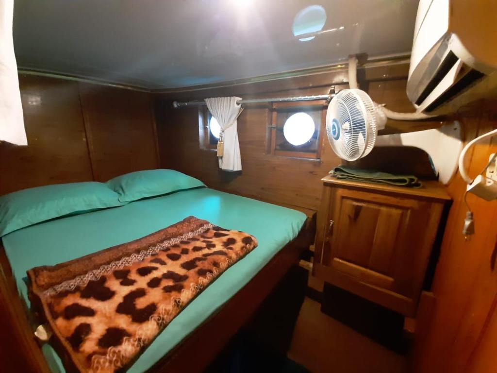 纳闽巴霍Exploring komodo island的小房间设有一张床和一个风扇