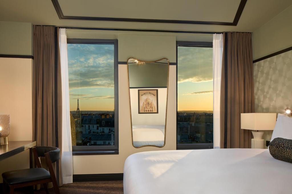 巴黎Maison Cassandre的酒店客房设有一张床和一个大窗户