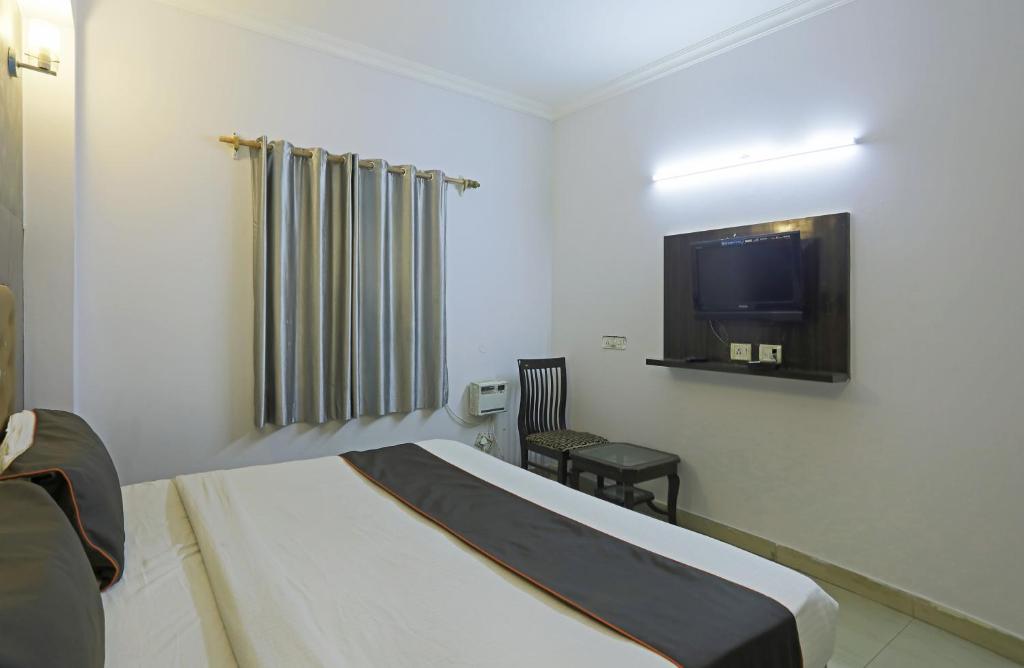新德里Airport KINGDOM的一间酒店客房,配有一张床和一台电视