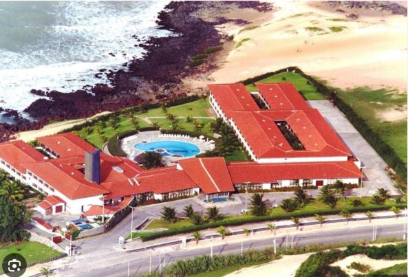 纳塔尔Pontal do Atlântico Resort的享有带游泳池和海洋的度假村的空中景致