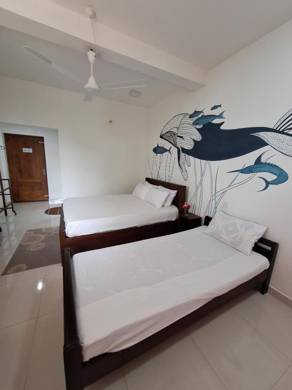卡尔库达Baden Beach的墙上壁画的房间里设有两张床