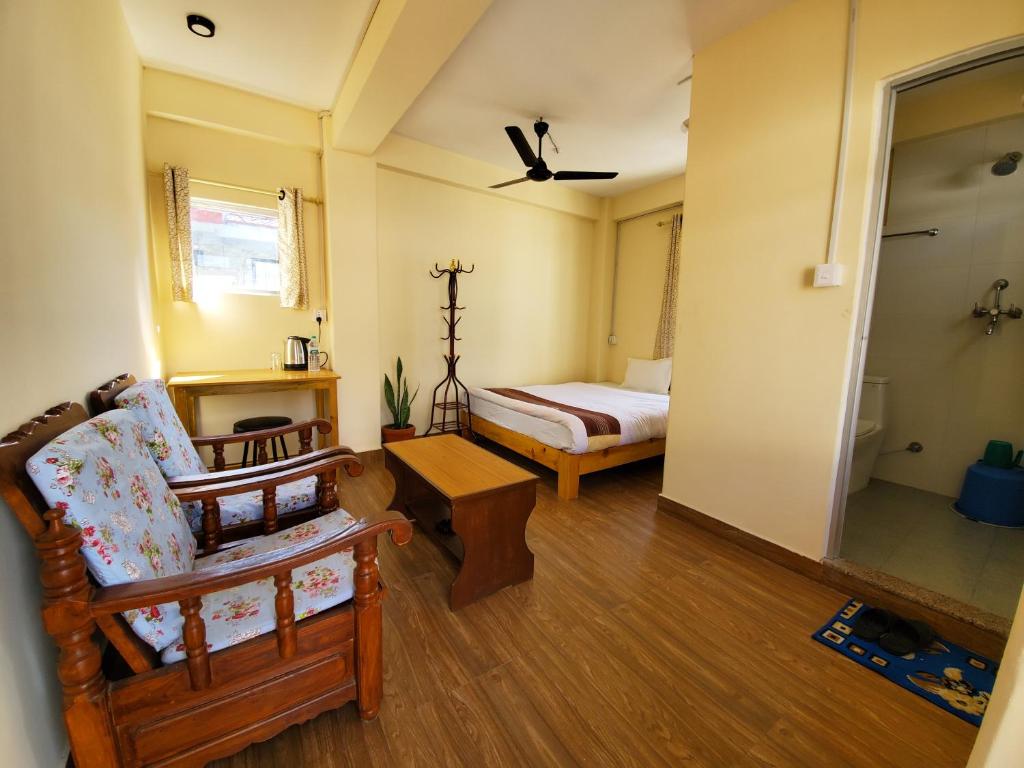 博卡拉santoshi guest house的一间带一张床和椅子的卧室