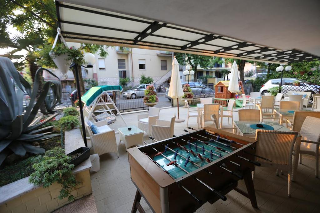 里米尼villa Anny的庭院配有桌椅和遮阳伞。