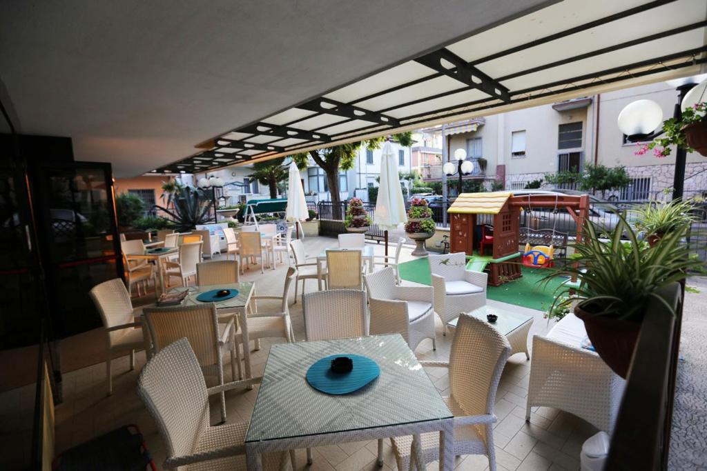 里米尼villa Anny的庭院配有桌椅和桌椅