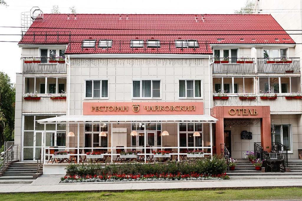 柴可夫斯基Отель Чайковский的白色的建筑,有红色的屋顶
