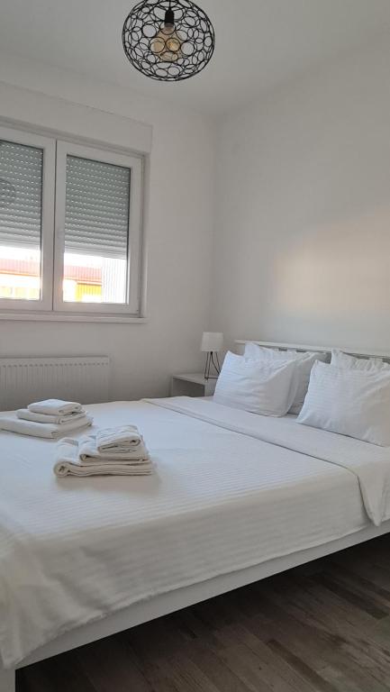 巴尼亚科维利亚查Apartmani Iva的一张白色的床,上面有两条毛巾