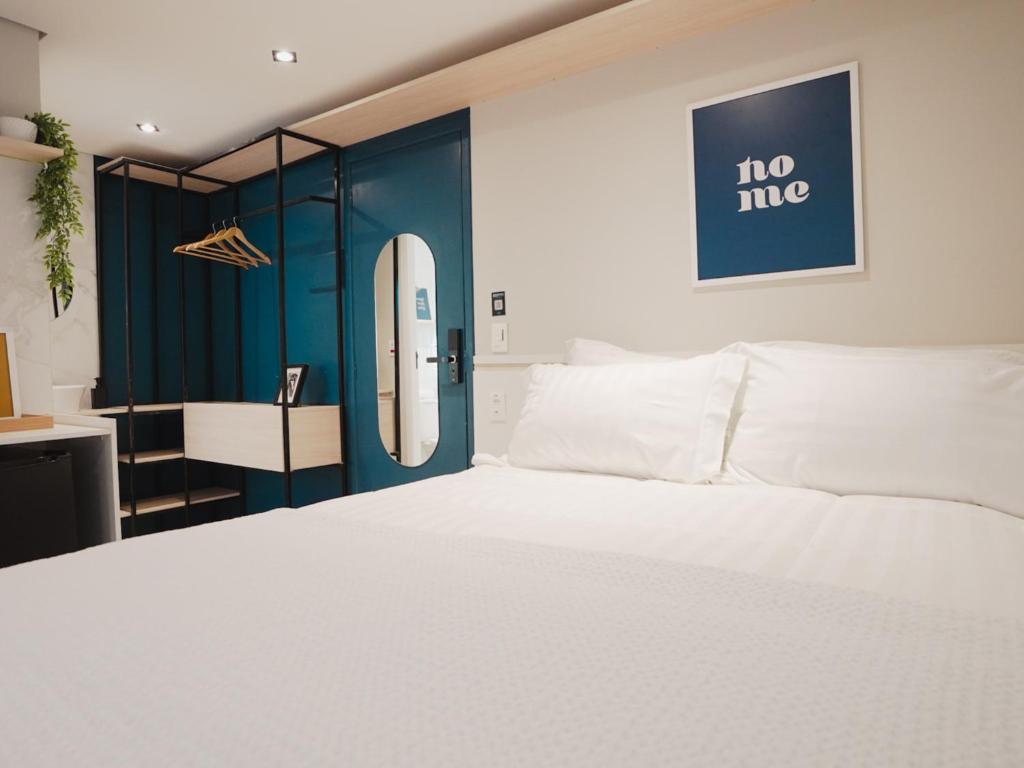 圣保罗Apê Paulista Bela Cintra的卧室配有白色的床和蓝色的墙壁