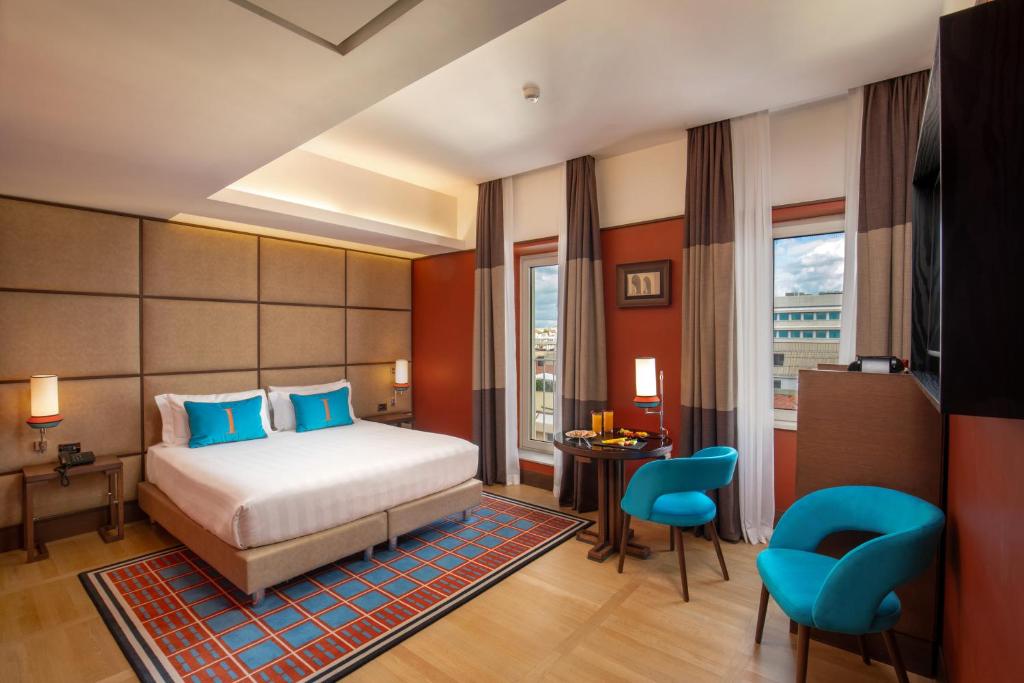 罗马独立酒店的卧室配有一张床、一张桌子和椅子
