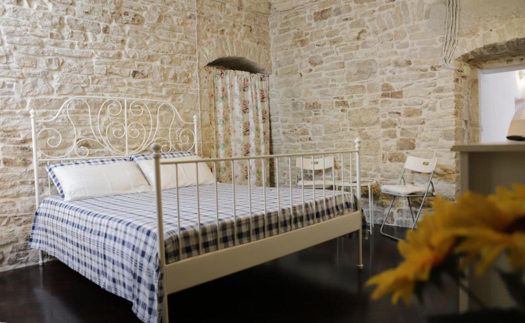 鲁沃迪普利亚La Petite Maison的一间卧室设有一张床和砖墙