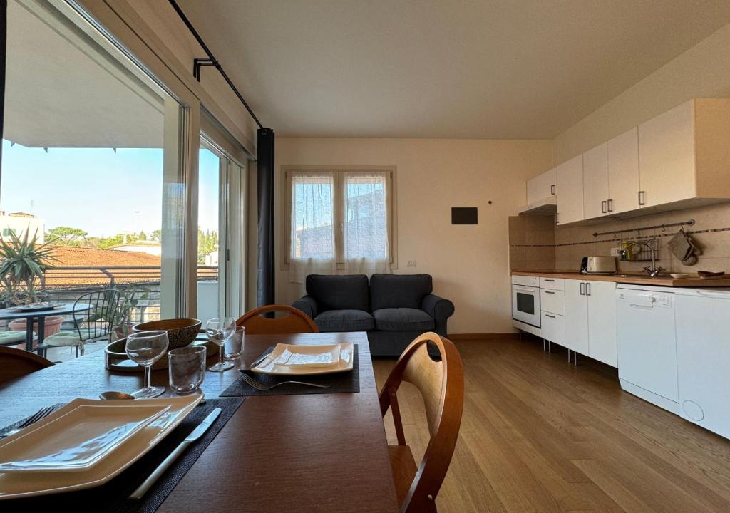 罗马Maison Linda - Ponte Milvio Apartment的厨房以及带桌子和沙发的客厅。