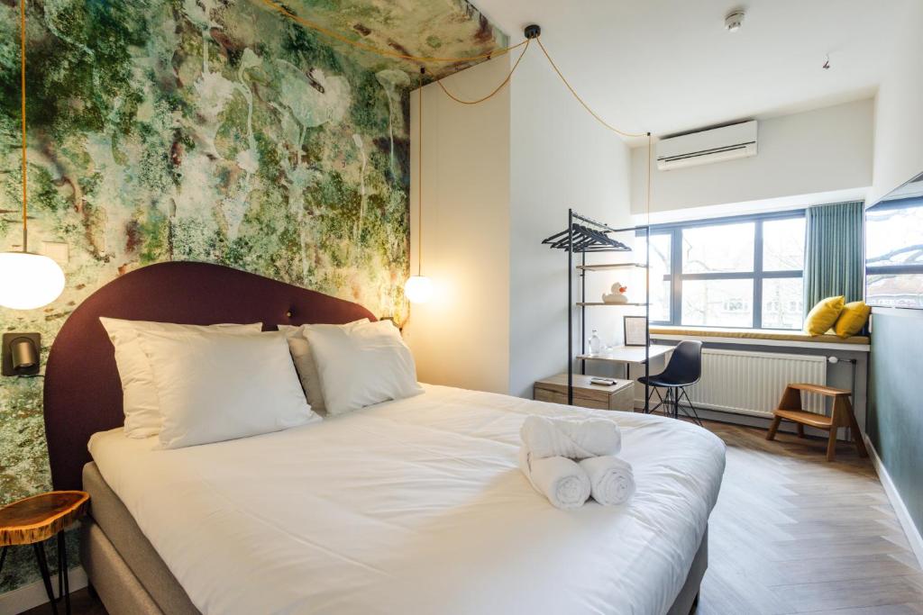 乌得勒支Badhuis Hotel的一间卧室配有一张床,上面有两条毛巾
