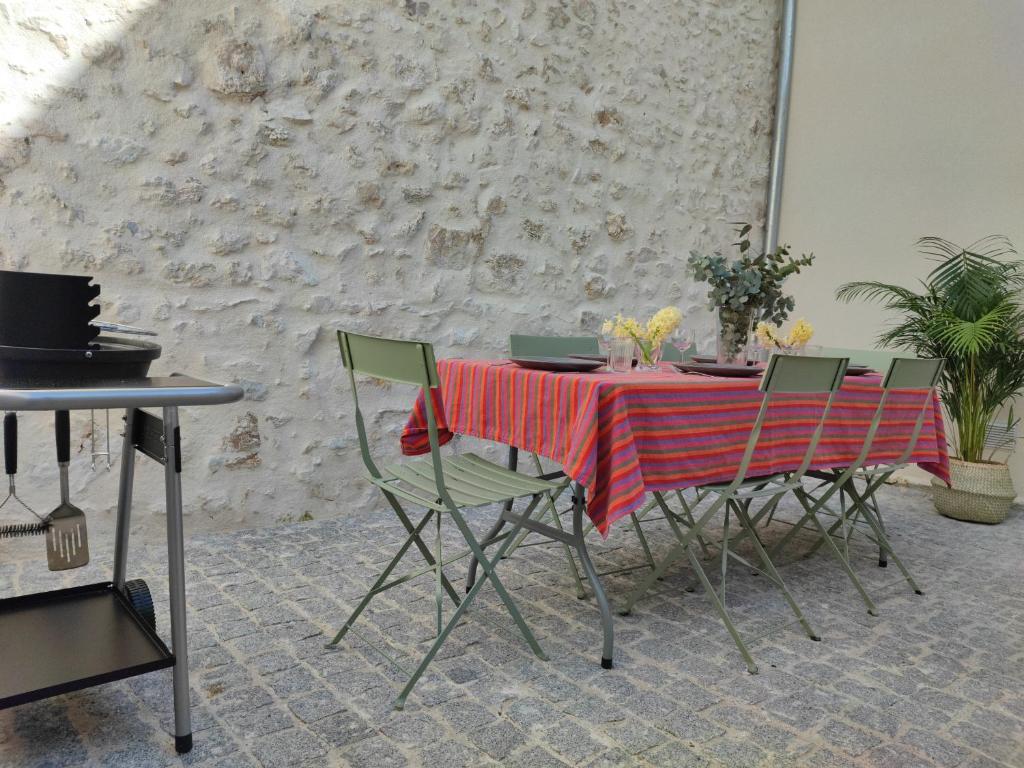 奥尔良Maison rénovée-moderne avec cour à 2 pas du centre的一张桌子、绿色椅子和红色桌布