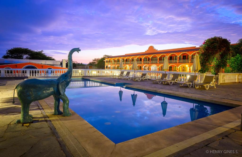 伊察Hacienda San Juan Resort的一座建筑物前的恐龙雕像