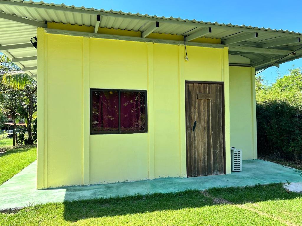 希门尼斯港Cabina Del Sol的草上有一扇门的黄色房子