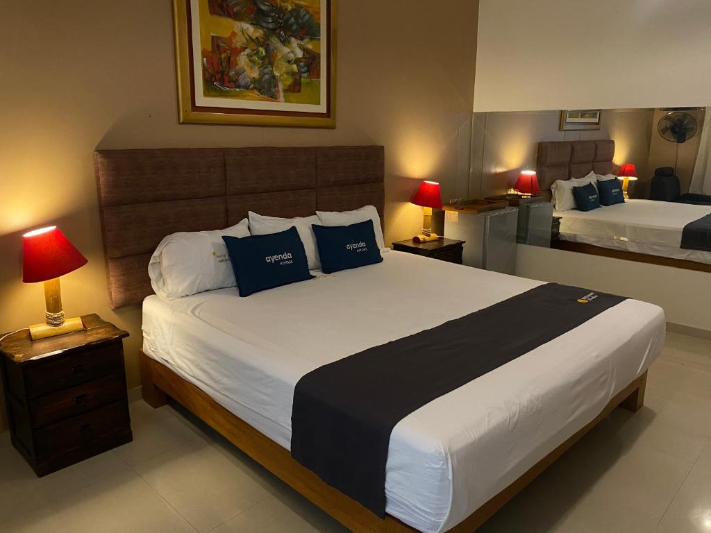 皮乌拉Suite Apart Miraflores的一间卧室配有一张带蓝色枕头的大床