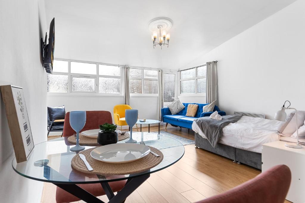伦敦Spacious Studio High Street Location的客厅配有桌子和床。
