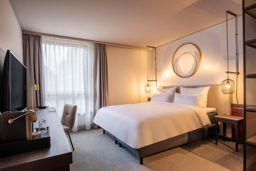 纽伦堡Scandic Nürnberg Central的配有一张大床和镜子的酒店客房