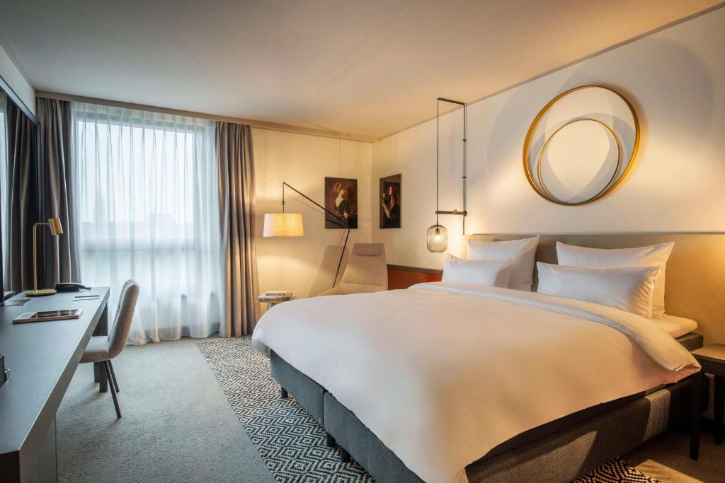 纽伦堡Scandic Nürnberg Central的配有一张大床和镜子的酒店客房