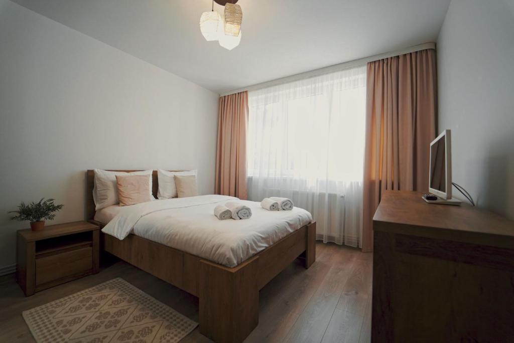 苏恰瓦Luxury Apartament Ultracentral of Suceava Esplanada的一间卧室配有一张床、一张书桌和一台电视