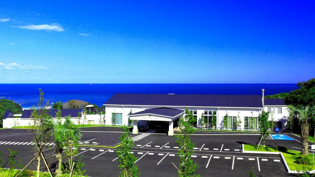太地町HOTEL HOLISTIC RESORT - Vacation STAY 34557v的一座在海洋前设有停车位的建筑