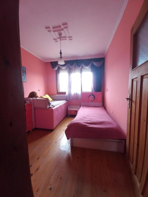 桑丹斯基Къща в село Катунци的粉红色的房间,配有床和沙发