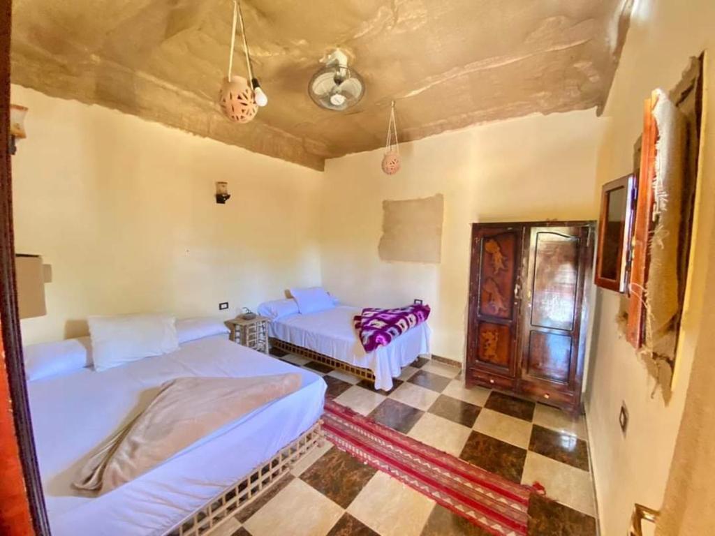 锡瓦غزاله كامب的一间卧室设有两张床,铺有一个 ⁇ 板地板