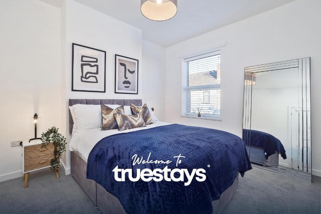 特伦特河畔斯托克Nursery House by Truestays - 3 Bedroom House in Stoke-on-Trent的一间卧室配有一张带蓝色棉被的床