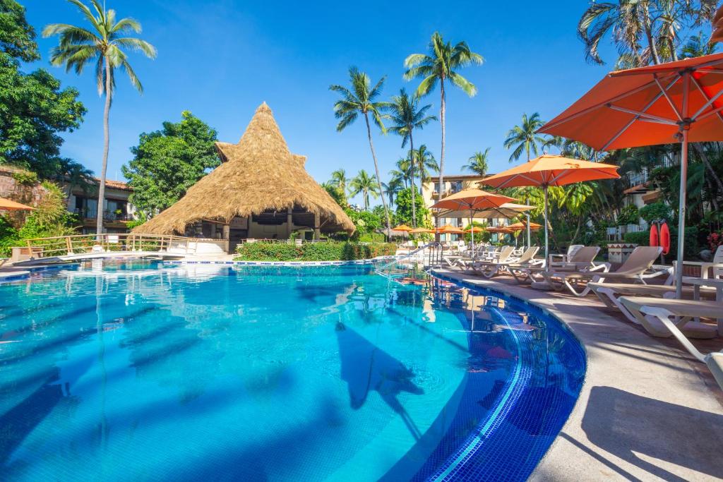 巴亚尔塔港布埃纳文图拉庄园墨西哥魅力酒店 - 全包 的度假村的游泳池,配有椅子和遮阳伞