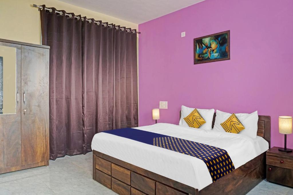 LohogaonOYO MYRA SERVICED APARTMENTS的一间卧室设有一张紫色墙壁的大床