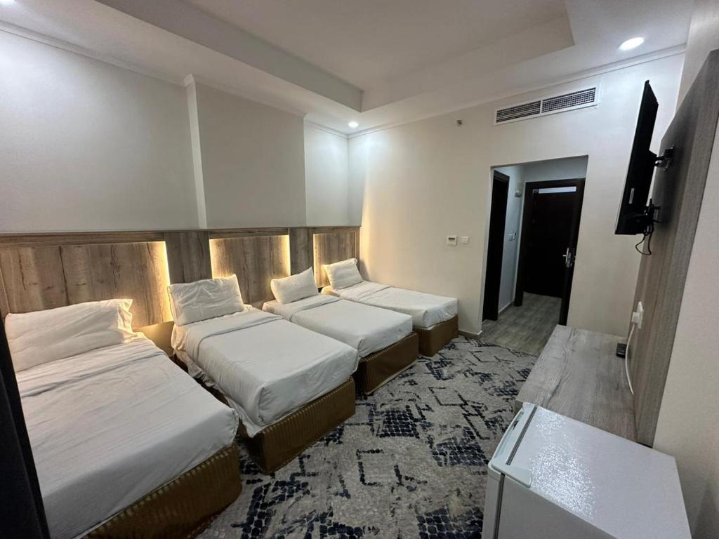 麦加جوهرة الديارJawaharat Al Diar的酒店客房设有三张床和电视。