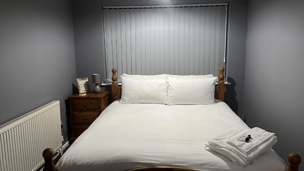 索利赫尔Becky's Lodge - Strictly Single Adult Room Stays - No Double Adult Stays Allowed的一间卧室配有一张带白色床单的大床