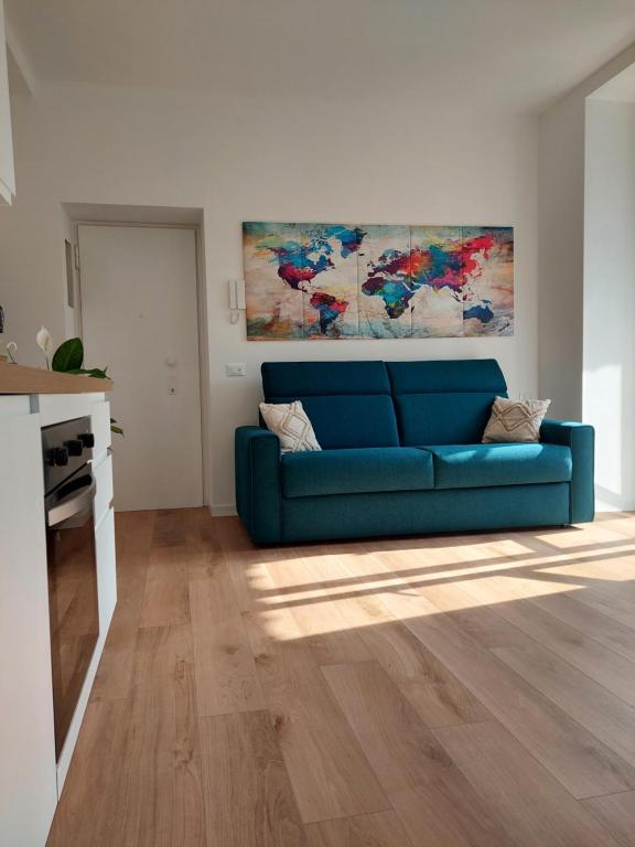 莱科Casa Mappamondo的客厅配有蓝色沙发和绘画作品