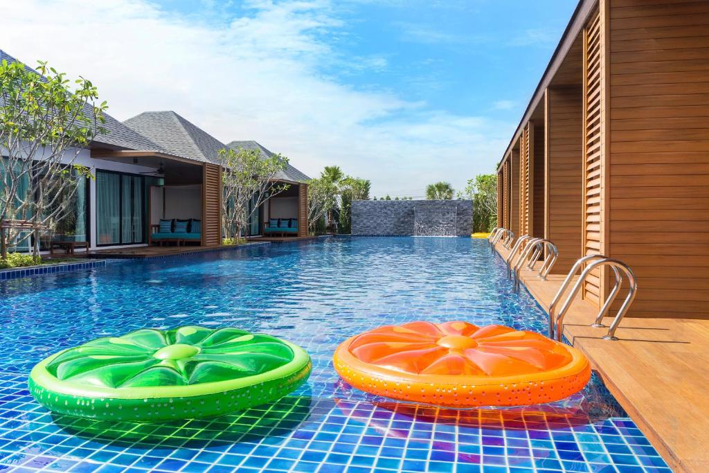 七岩范恩华欣度假酒店的游泳池上有两个五颜六色的充气池