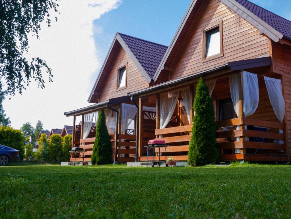 德布吉Domki Rejs的一座带绿色草坪的大型木屋