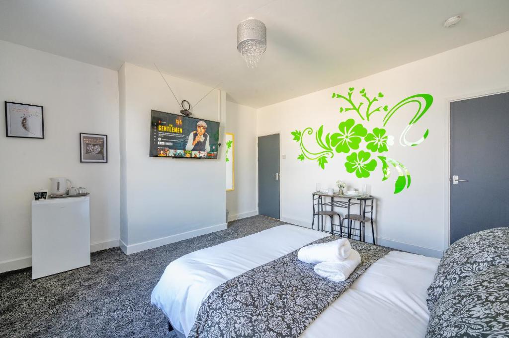 利兹*RC246*For your relaxed & Cosy stay + Free Parking的一间卧室设有两张床,墙上配有电视。