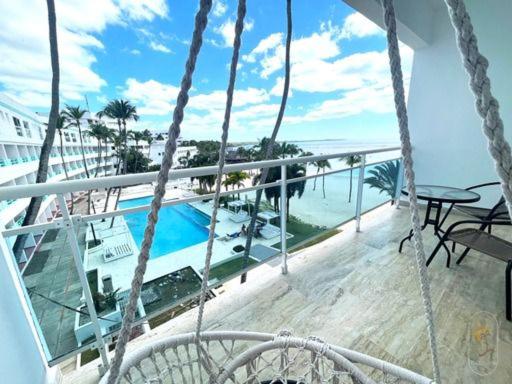 CuevasSuites Presidencial Boca chica的阳台享有游泳池和海洋的景致。